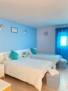 2 letti in una camera con pareti blu di Cabedelo Seaside Guesthouse a Viana do Castelo