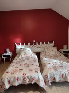 2 camas en un dormitorio con una pared roja en GITE DE MONTRANCON, 
