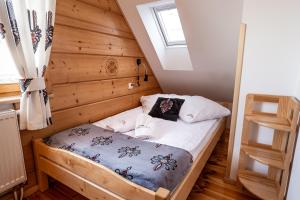 Cama pequeña en habitación con ventana en HRYCÓWKA Domki z Widokiem, en Grywałd