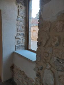 ventana en una pared de piedra con bañera en Cal Vallverdú - Adaptado, en Preixana