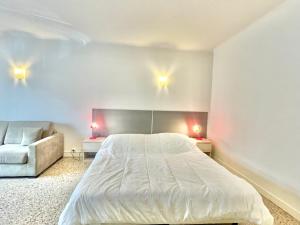een slaapkamer met een groot bed en een bank bij Themis by Welcome to Cannes in Cannes