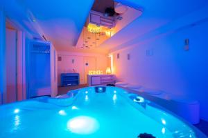 um quarto com uma banheira com luzes azuis em iConic Wellness Resort & Spa em Arezzo