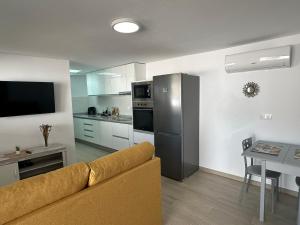 a living room with a couch and a kitchen at Apartamentos Casa Mime in Mogán