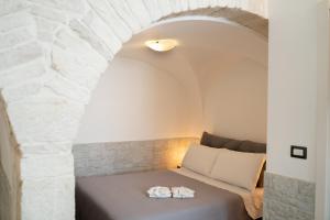 Cama en habitación con pared de piedra en La Casa di Saretta, en Terlizzi