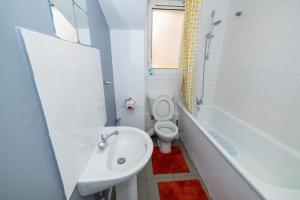 a bathroom with a sink and a toilet and a tub at Rooms Close to Canary Wharf in London