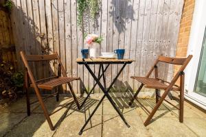 a table and two chairs sitting next to a fence at Rooms Close to Canary Wharf in London