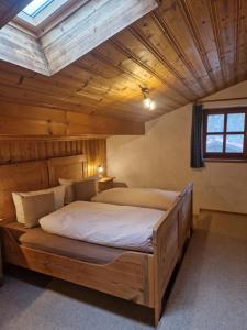 Un dormitorio con una cama grande en una habitación con techos de madera. en Huberhof, Mettenham, en Schleching