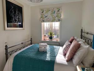 een slaapkamer met een bed met een groen dekbed en een raam bij Clocktower Suite in Exeter