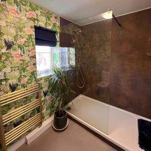 a bathroom with a tub and a plant in it at Clocktower Suite in Exeter