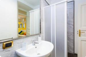 uma casa de banho com um lavatório branco e um espelho. em Case Calliope em Palermo