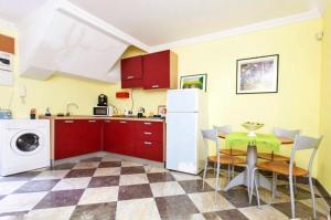 uma cozinha com armários vermelhos e uma mesa com cadeiras em Case Calliope em Palermo