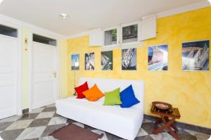 uma sala de estar com um sofá branco com almofadas coloridas em Case Calliope em Palermo