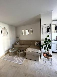 ein Wohnzimmer mit einem Sofa und einem Tisch in der Unterkunft Joli studio près des plages in Mandelieu-la-Napoule