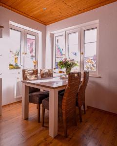 a dining room with a table with chairs and windows at Veras Kate - Hunde Willkommen in Krummhörn