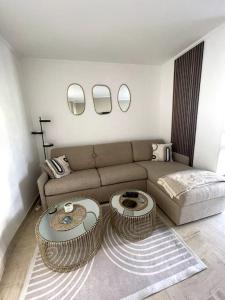 ein Wohnzimmer mit einem Sofa und 2 Tischen in der Unterkunft Joli studio près des plages in Mandelieu-la-Napoule
