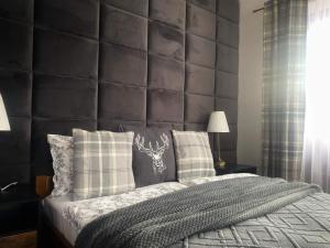 - une chambre avec un grand lit et une grande tête de lit rembourrée dans l'établissement Apartament Sichlański, à Murzasichle