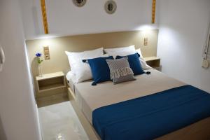 una camera da letto con un letto con cuscini blu e bianchi di Elean a Kavoúsion