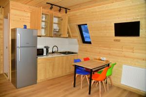 古道里的住宿－Kai cottage，厨房配有桌椅和冰箱。