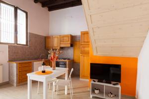 ローマにあるBoccanera a Trastevere Holiday Apartmentのキッチン(白いテーブル、テレビ付)
