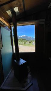 - une fenêtre d'une chambre avec une cuisinière et une vue dans l'établissement Cabaña de la nona, à Futaleufú