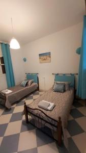 - une chambre avec 2 lits et un sol en damier dans l'établissement Perle d'Azur F3, à Saïdia