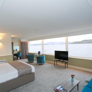 Habitación de hotel con cama y TV de pantalla plana. en Duck Bay Hotel & Restaurant en Balloch