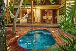 a house with a swimming pool on a wooden deck at Vila Nativa Caraíva in Caraíva