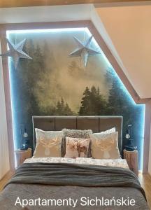 a bedroom with a bed with stars on the wall at Apartamenty Sichlańskie in Murzasichle