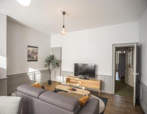 a living room with a couch and a tv at Chez Suzanne 0 - Chambre Privée dans Maison de Ville - Confort - Hypercentre in Troyes