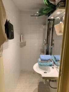 een witte badkamer met een wastafel en een spiegel bij Jungle Magic Room near Atomium , Heyzel Stadium in Strombeek-Bever
