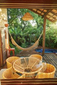uma rede de descanso num deque com cadeiras e uma mesa em Vila Nativa Caraíva em Caraíva