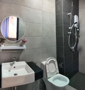 bagno con lavandino, servizi igienici e specchio di Ocean Home@Urban Suites@12 Pax a Jelutong