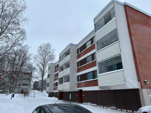 un edificio de apartamentos con nieve delante en Chic and Relaxing Studio, en Hyvinkää