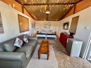 ein Wohnzimmer mit einem Sofa und einem Tisch in der Unterkunft Daureb Isib Campsite and B&B in Uis
