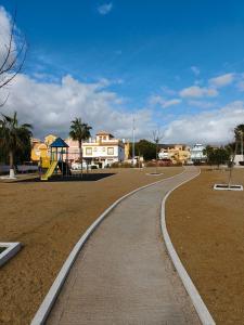 a curved path in a park with a playground at Casa Trastévere in San Juan de los Terreros