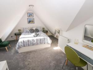 a attic bedroom with a bed and a desk at 12 Clos Yr Wylan in Barry