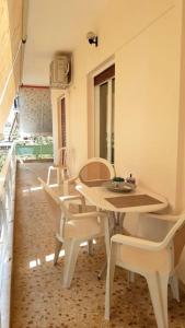 a dining room with a table and white chairs at Cozy apartment next to metro station in Athens