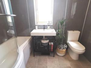 a bathroom with a sink and a toilet and a window at Charming North Norfolk flint cottage in Baconsthorpe