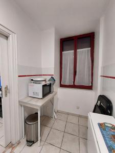 a kitchen with a table with a microwave on it at Studio en résidence parking couvert gratuit in Peyraud