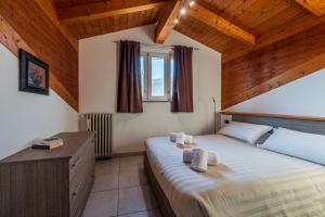 ein Schlafzimmer mit einem Bett in einem Zimmer mit Holzdecken in der Unterkunft In Piazzetta holiday apartments, Barolo in Barolo