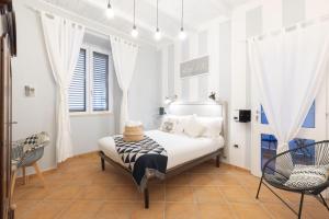1 dormitorio blanco con 1 cama y 2 sillas en Cagliari Old Town B&B, en Cagliari