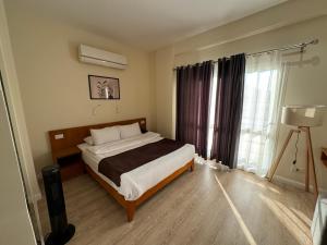 um quarto com uma cama e uma grande janela em Marron Serviced Studios and Rooms em Cairo