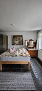 1 dormitorio con 1 cama con una pintura en la pared en Ferienwohnungen Heinrichsberger, en Bad Aibling
