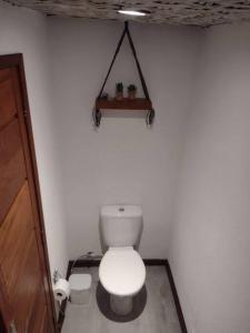 baño con aseo y estante en la pared en Casa do Zabumba, en Ilhabela