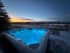 een jacuzzi in de sneeuw bij zonsondergang bij Whitehouse Woodwrae in Forfar