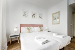 a white bedroom with a large white bed with two pillows at Awesome views and walk to the beach! RDR316 in Marbella