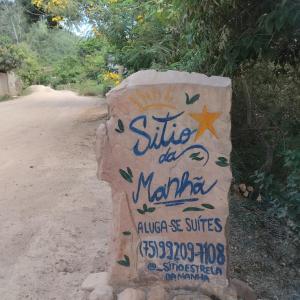 um sinal no lado de uma estrada de terra batida em Sítio Estrela da Manhã em Palmeiras