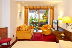 a living room with a couch and two chairs at Kurhotel Eichinger in Bad Wörishofen