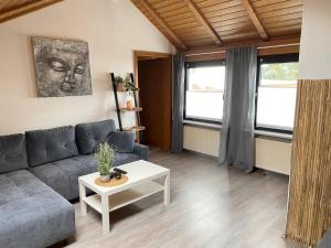 uma sala de estar com um sofá e uma mesa em Ferienwohnung Fischer in Rödental em Rödental