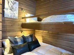 sypialnia z 2 łóżkami w drewnianej ścianie w obiekcie Varglyan - Idre w mieście Idre